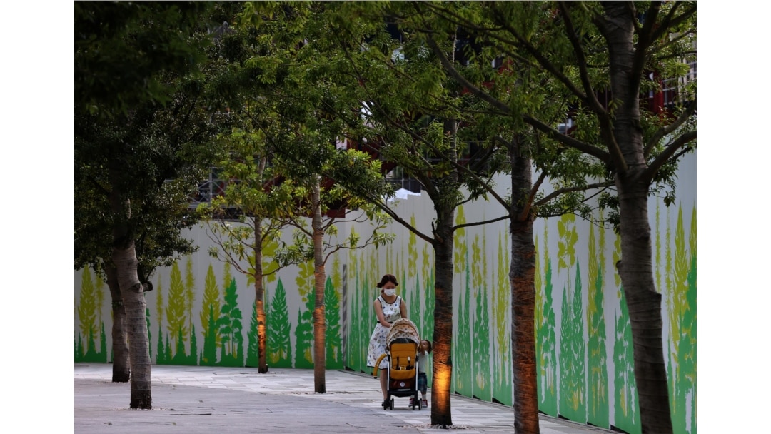 A woman wearing a protective mask, amid the coronavirus disease (COVID-19) outbreak, pushes a stroller outside the National Stadium, the main venue of the Tokyo 2020 Olympic Games in Tokyo, Japan, July 28, 2021.
