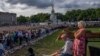 People stand in line after laying flowers for Queen Elizabeth II in front of Buckingham Palace, in London, Sunday, Sept. 11, 2022.