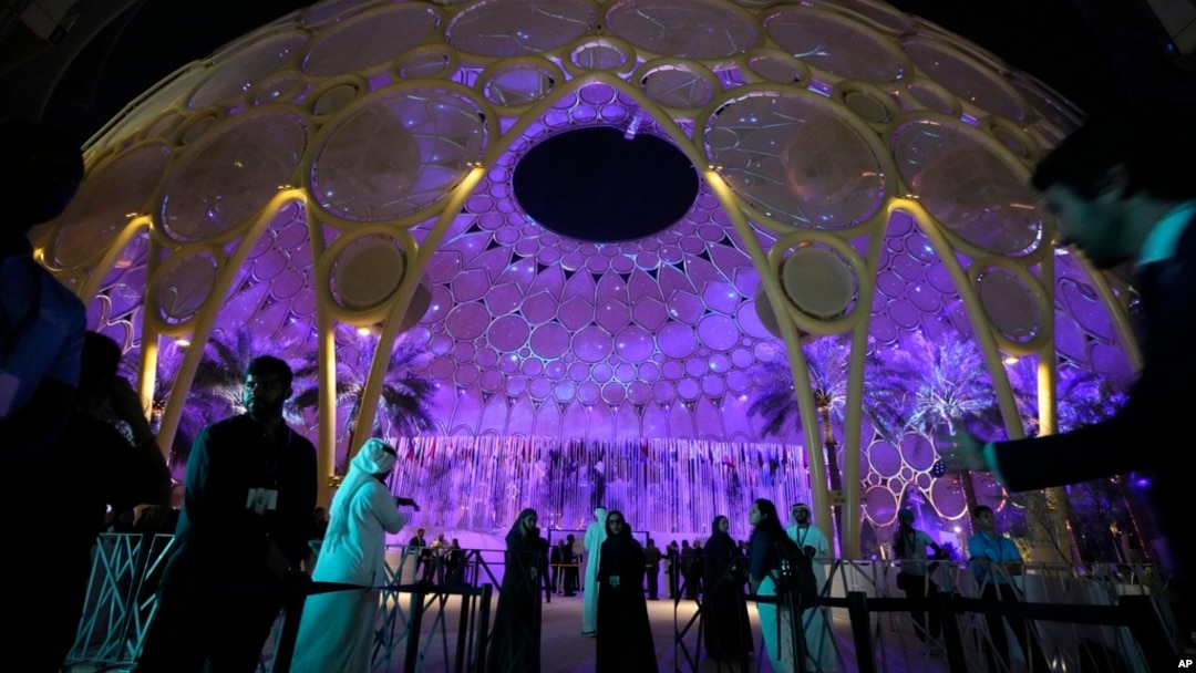 People walk near a lit up Al Wasl Dome at Expo City at the COP28 U.N. Climate Summit, Dubai, United Arab Emirates, Dec. 1, 2023.