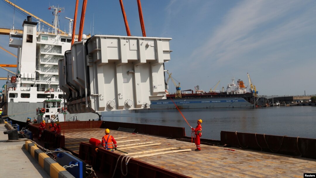 FILE - An autotransformer intended for the expansion of the Lithuanian-Polish electricity system connection LitPol Link is loaded on a barge in the port of Klaipeda, Lithuania, May 13, 2021.