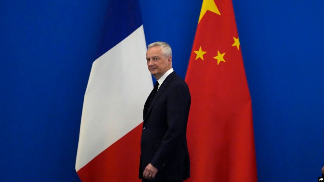 French Finance Minister Bruno Le Maire walks past the French and Chinese flags at the 9th China-France High Level Economic and Financial Dialogue held at the Diaoyutai State Guest House in Beijing, July 29, 2023. 