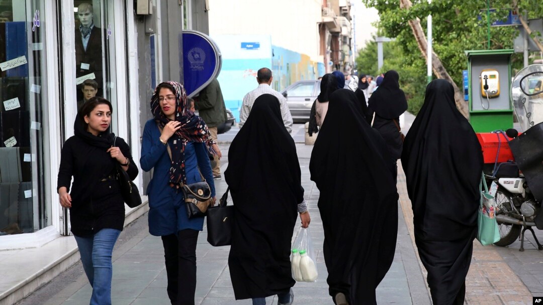 FILE - Iranian women make their way along a sidewalk in downtown Tehran, Apr. 26, 2016. 