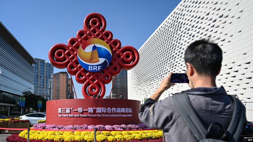 一名男子在北京宣傳一帶一路論壇的路標前拍照。（2023年10月16日）