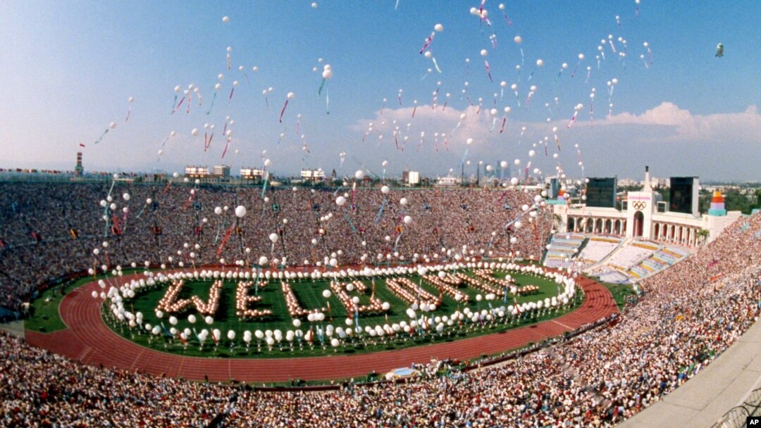 FILE - Some 1200 helium balloons are released into the air from the field of the Los Angeles Memorial Coliseum, July 28, 1984 as part of the opening ceremony for the XXIII Olympics.