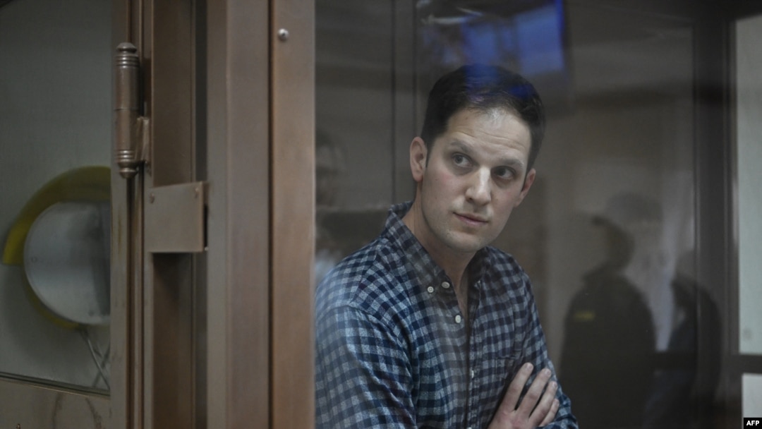 FILE — U.S. journalist Evan Gershkovich, arrested on espionage charges, stands in a defendants' cage at the Moscow City Court in Moscow, April 18, 2023. German authorities have said they are investigating an apparent poisoning of an exiled Russian journalist in Munich.
