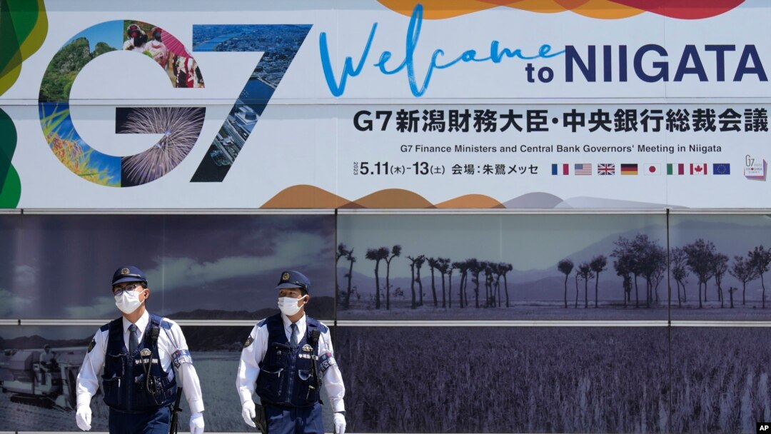日本警察巡邏走過新瀉街頭張貼的七國集團財長會議宣傳畫。（2023年5月10日）