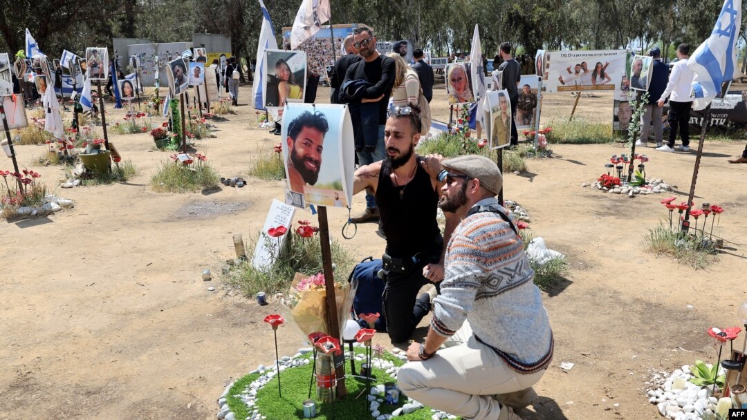 FILE - Israelis visit a memorial bearing portraits of people taken hostage or killed in the Hamas attack on the Supernova music festival on Oct. 7 at the site of the festival near Kibbutz Reim in southern Israel on April 10, 2024. 