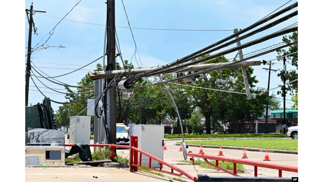 FILE - Utility polls wait for repair after being damaged by Hurricane Beryl in Houston, July 10, 2024.