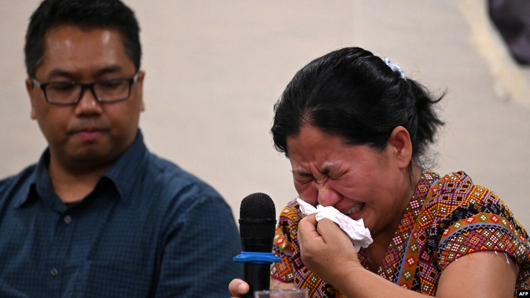 A Myanmar national reacts during a press conference after filing a criminal complaint in Manila, Philippines, Oct. 25, 2023. 