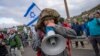 FILE - Israeli military reservists protest against the plans by Prime Minister Benjamin Netanyahu's new government to overhaul the judicial system, on a freeway from Tel Aviv to Jerusalem, Feb. 9, 2023. 