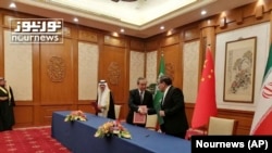 2023年3月10日，伊朗最高國家安全委員會秘書阿里·沙姆哈尼(Ali Shamkhani)（右）在北京的會談結束後同中共中央政治局委員、中央外辦主任王毅握手。照片最左邊是沙特國務大臣、內閣成員和國家安全顧問穆薩伊德·本·穆罕默德·艾班。