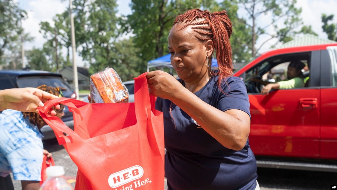 Debra McCarty with Harris County Precinct 1 works to distribute food at Lincoln Park in Houston, on July 10, 2024.