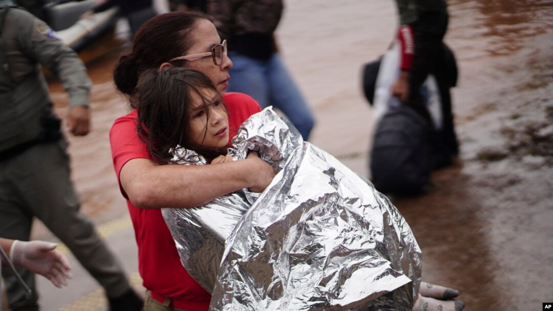 A firefighter carries a girl rescued from an area flooded by heavy rains in Porto Alegre, Rio Grande do Sul state, Brazil, May 4, 2024. 