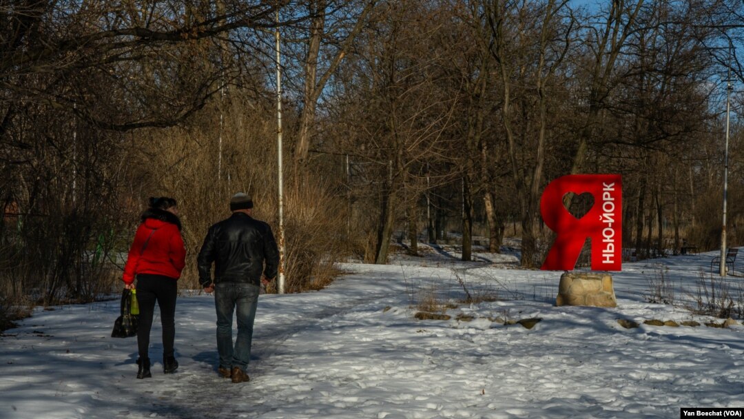 A couple passes by a landmark celebrating the love of the citizens for the little frontline city of New York in the Donetsk region, Ukraine, on Feb. 20, 2023.