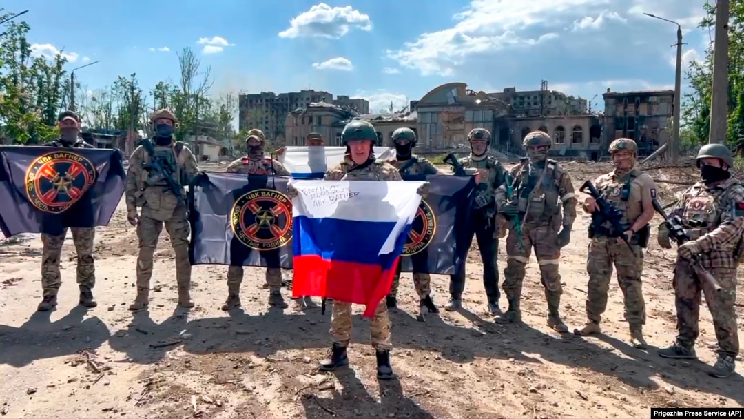 In this handout photo taken from video and released by Prigozhin Press Service, May 20, 2023, Yevgeny Prigozhin, the head of the Wagner Group military company holds a Russian national flag in Bakhmut, Ukraine. (Prigozhin Press Service/AP)