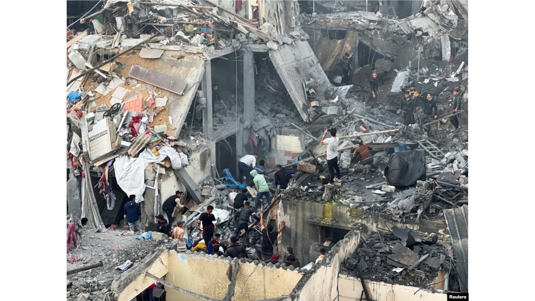 People search through the rubble of damaged buildings following an Israeli air strike on Palestinian houses, amid the ongoing conflict between Israel and the Palestinian Islamist group Hamas, in Rafah in the southern Gaza Strip, Dec. 12, 2023.