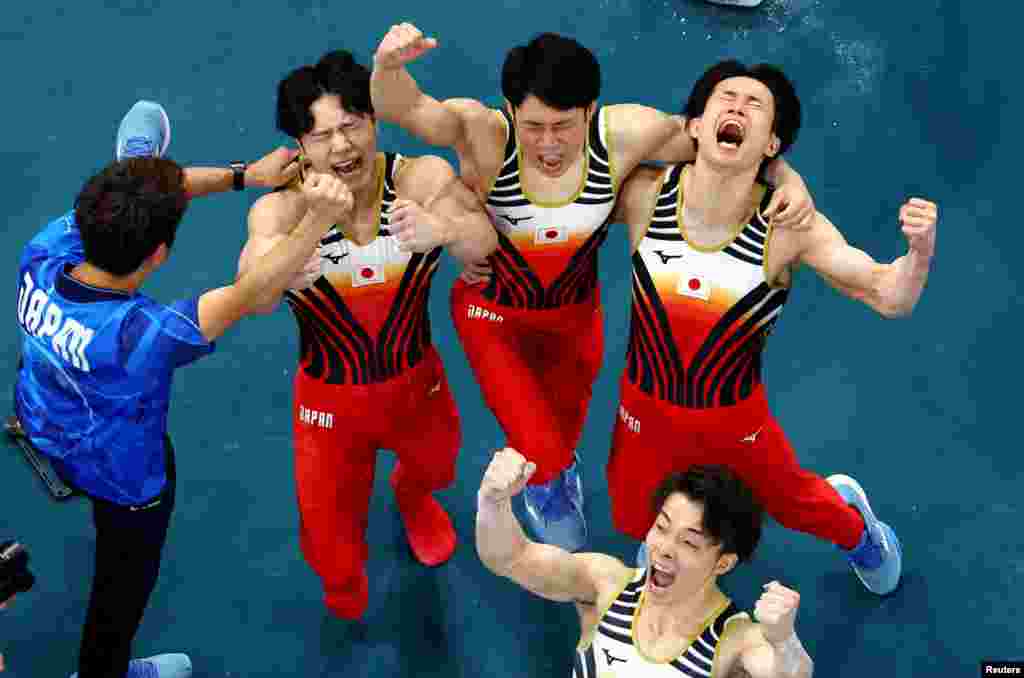 Japan's Kazuma Kaya, Shinnosuke Oka, Takaaki Sugino and Wataru Tanigawa celebrate their winning the artistic gymnastics men's team final during the Paris 2024 Olympic Games at the Bercy Arena in Paris, July 29, 2024.