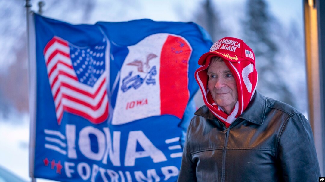 FILE - A man stands next to a flag that reads "Iowa for Trump" outside the the Machine Shed in Urbandale, Iowa, Jan. 11, 2024. 