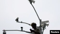 一名男子在上海街頭的攝影機下看手機。（2023年9月27日）