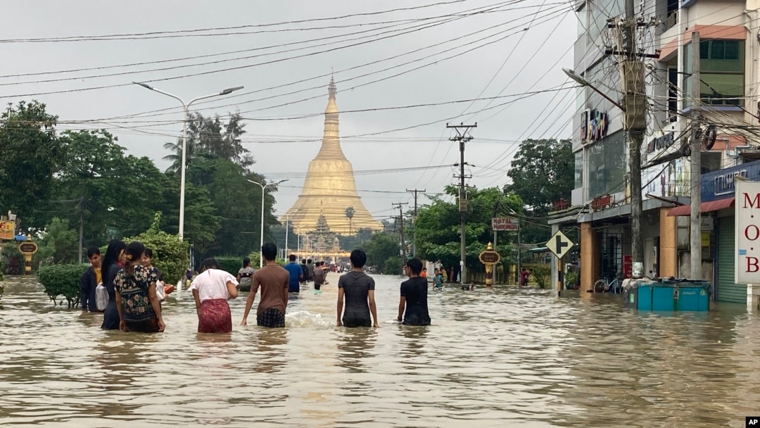Local residents wade through a flooded road near Shwe Maw Taw pagoda in Bago, about 80 kilometers (50 miles) northeast of Yangon, Myanmar, Oct. 9, 2023. 
