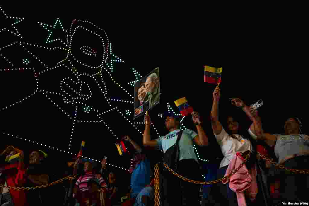 Supporters of Nicolas Maduro celebrate the Venezuelan president's re-election announcement at the Miraflores Palace, while drones draw the face of the Chavista leader in the skies above Caracas, July 29, 2024.