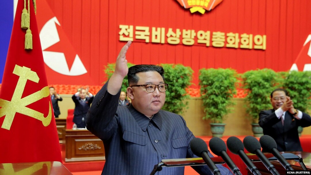 김정은(가운데) 북한 국무위원장이 10일 평양에서 열린 '전국비상방역총화회의' 연단에 나와 오른손을 들어올리고 있다. 