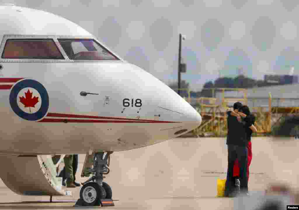 Former diplomat Michael Kovrig embraces his wife Vina Nadjibulla following his arrival on a Canadian air force jet after his release from detention in China, at Pearson International Airport in Toronto, Ontario, Canada, Sept. 25, 2021.