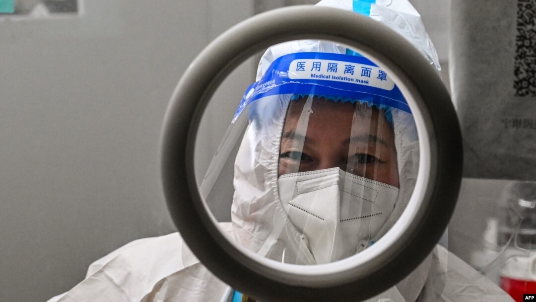 A health worker waits for people to take swab samples to test for COVID-19 in the Jing'an district in Shanghai on Dec. 23, 2022.