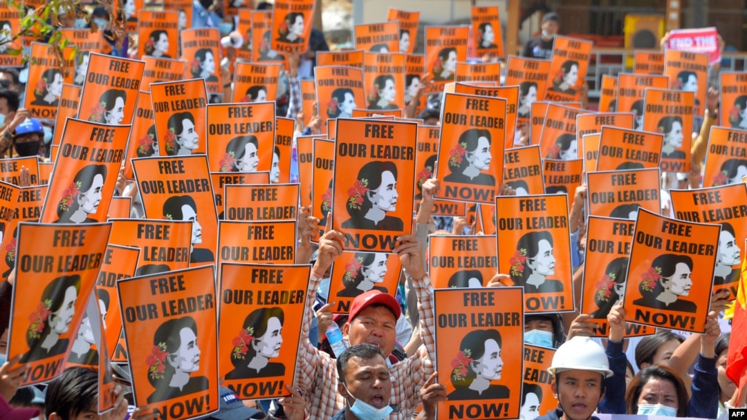 FILE - In this Feb. 28, 2021, photo protesters hold posters with the image of detained civilian leader Aung San Suu Kyi during a demonstration against the military coup in Naypyidaw, Myanmar.