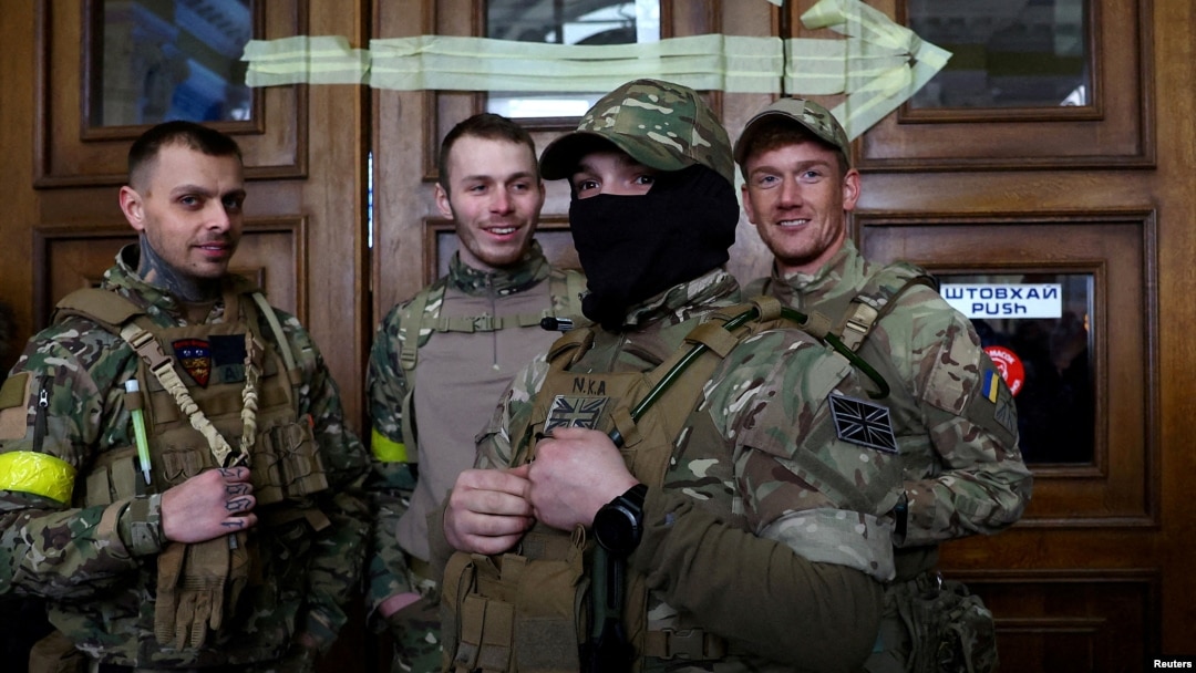 FILE - Four foreign fighters from the UK pose for a picture prior to their departure towards the front line in the east of Ukraine following the Russia's invasion, at the main train station in Lviv, western Ukraine, March 5, 2022. 