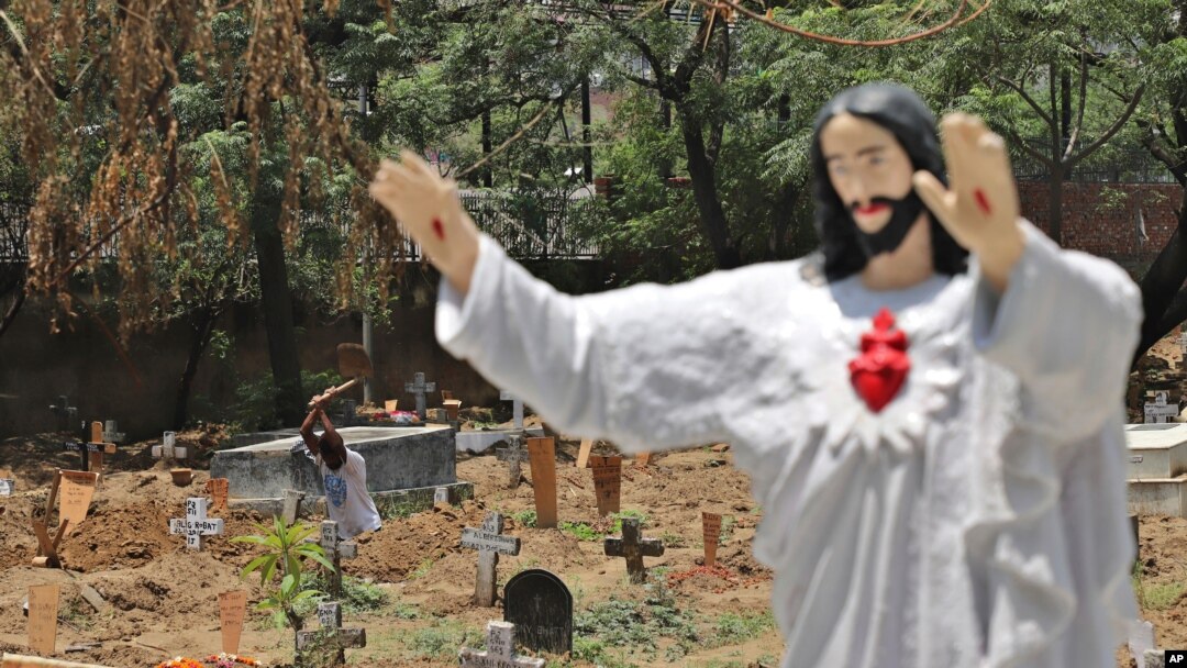 A worker prepares the grave for a COVID-19 victim at a Christian cemetery in New Delhi, India, May 21, 2021.