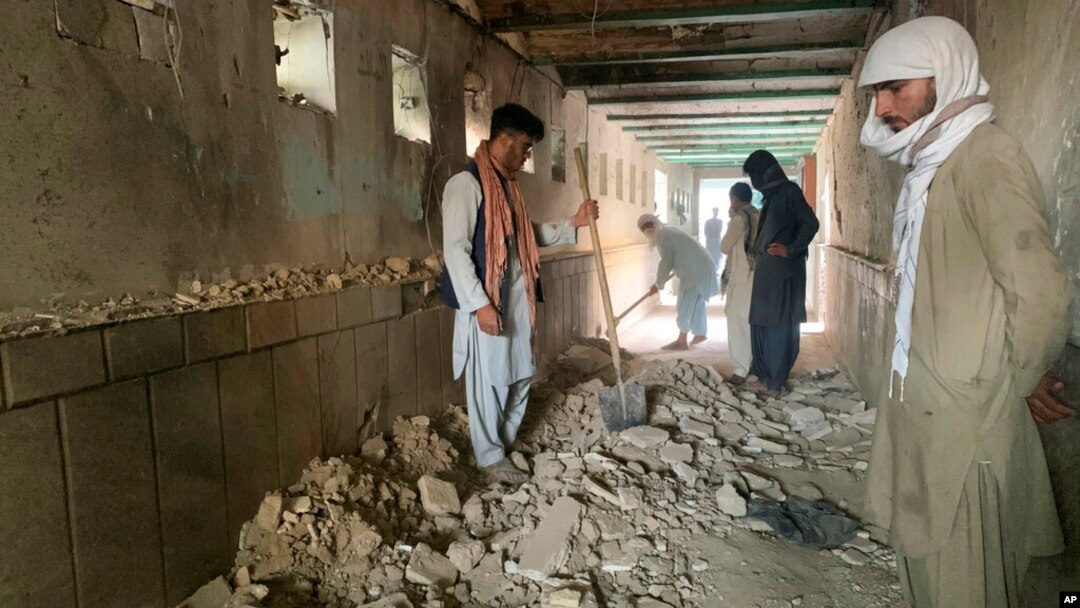 People inspect the inside of a mosque following a suicide bombers attack in the city of Kandahar, southwest Afghanistan, Oct. 15, 2021.
