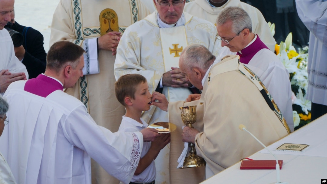 Pope Francis gives Holy Communion during the canonization Mass for 10 new saints in St. Peter's Square at The Vatican, Sunday, May 15, 2022. 