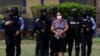 Agentes de la policía hondureña escoltan a Herlinda Bobadilla, acusada de liderar un cartel del narcotráfico, en Tegucigalpa, Honduras, 15 de mayo de 2022. Foto Reuters.
