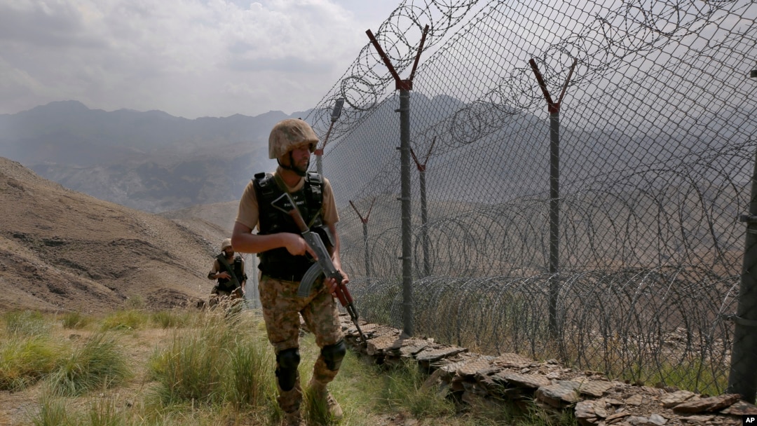 FILE - Pakistan Army troops patrol along the fence on the Pakistan-Afghanistan border at Big Ben hilltop post in Khyber district, Pakistan, Aug. 3, 2021.