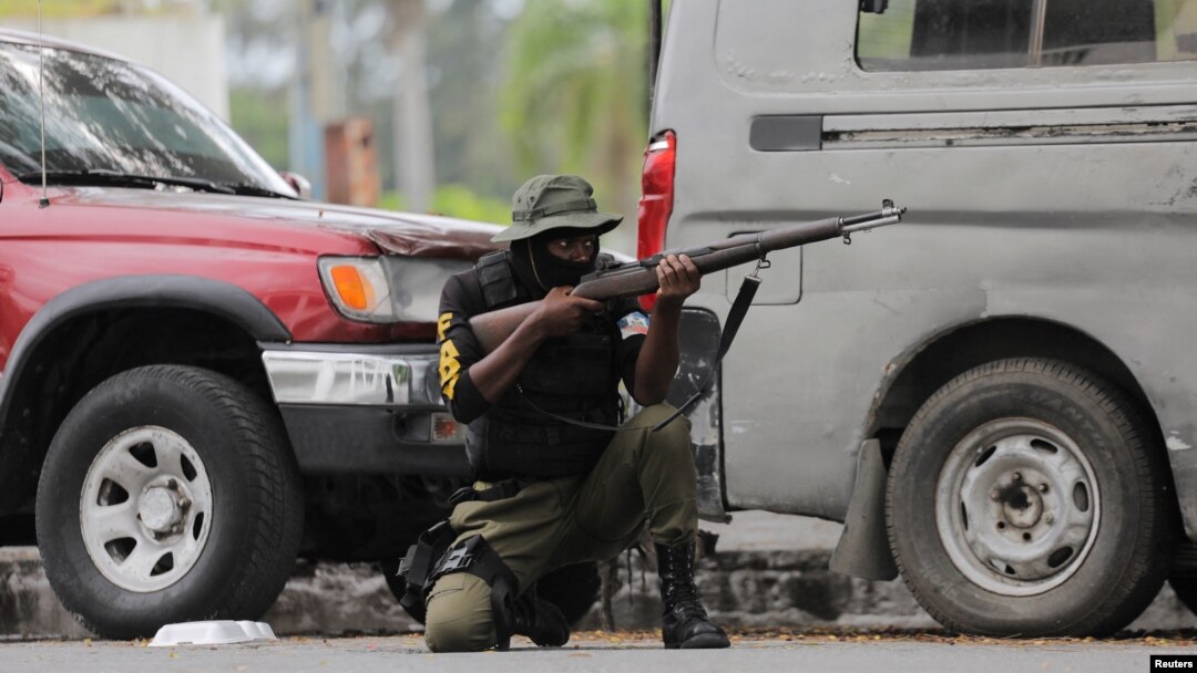 FILE - A soldier positions himself outside the military base near the presidential palace in Port-au-Prince, Haiti, after gangs waged intense gun battles, shuttering main avenues and a municipal market in the downtown area, July 27, 2022. 