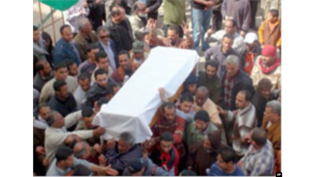 Mourners outside the Benghazi courthouse, seat of the rebel movement, carry the coffin of a victim of a munitions depot blast, March 5, 2011