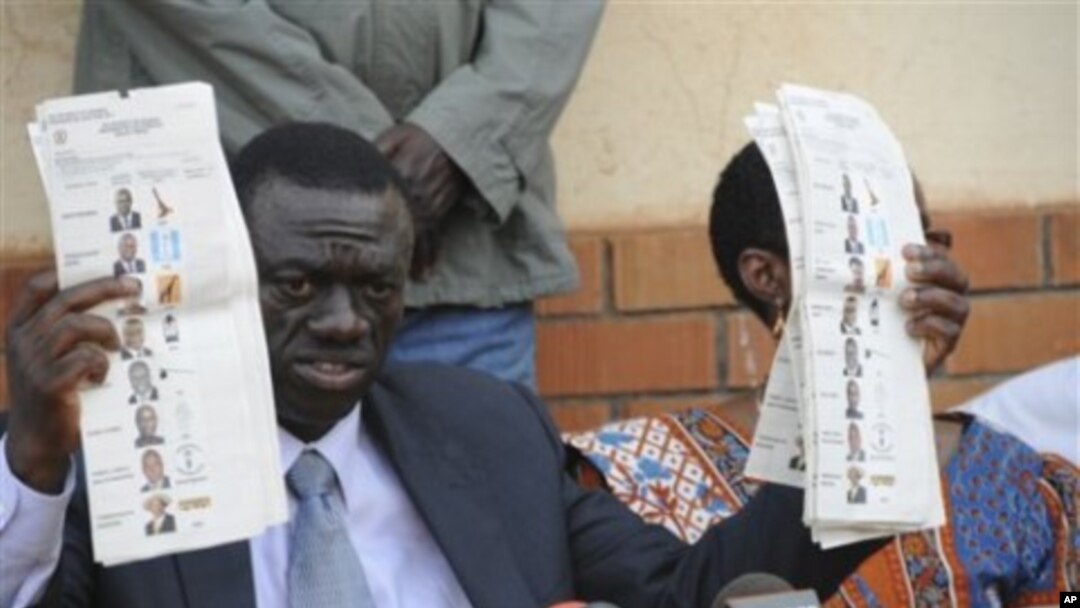 Forum for Democratic Change opposition leader Dr. Kizza Besigye displays pre-marked ballot papers, during a news conference at party headquarters in Kampala Uganda, February 19, 2011
