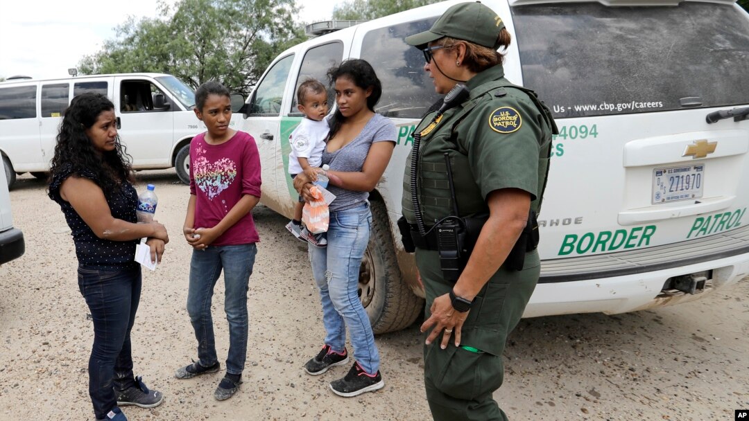 U.S. Border Patrol agent-in-charge Melissa Lucio, right, talks with women and children migrating from Honduras after they surrendered to U.S. Border Patrol agents after illegally crossing the border Monday, June 25, 2018, near McAllen, Texas. (AP Photo/Da