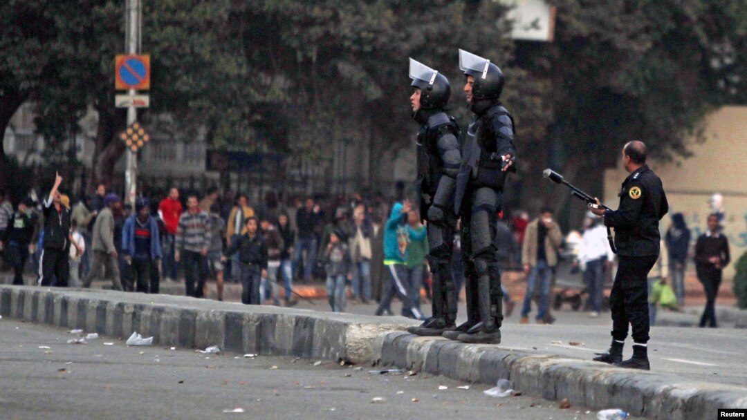 Riot police try to stop clashes and ask protesters, opposing Egyptian President Mohamed Mursi, to back away along Qasr Al Nil bridge, which leads to Tahrir Square in Cairo, Mar. 7, 2013. 