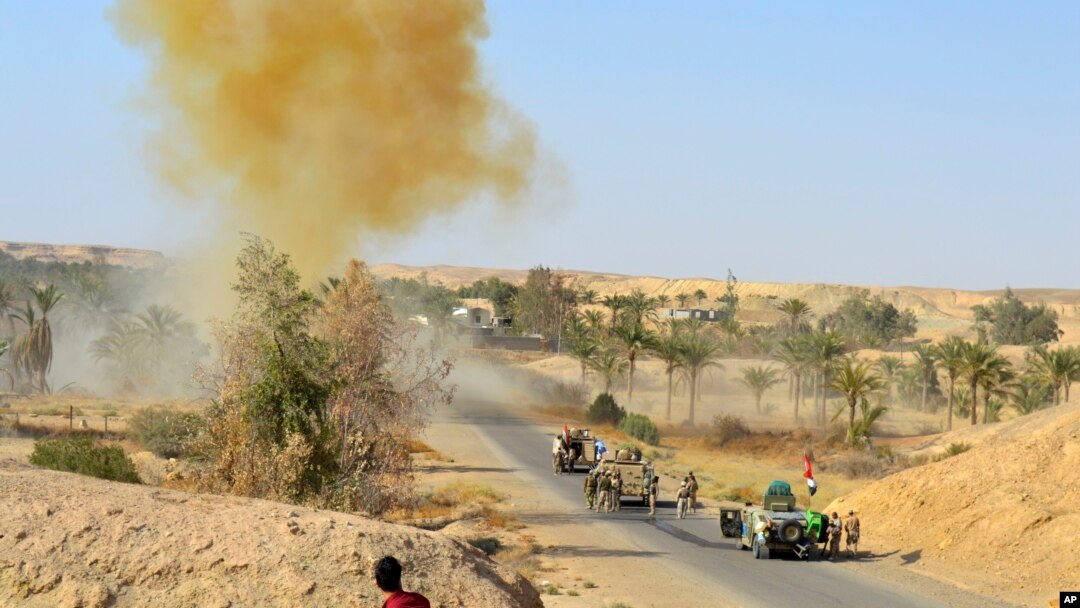 FILE - Iraqi army soldiers clear the roads of roadside bombs after defeating Islamic State extremists from villages outside Ramadi, west of Baghdad, Oct. 10, 2016.