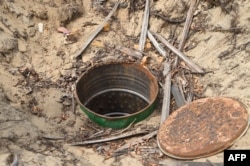 FILE - A deep hole dug by vandals to steal oil from pipelines belonging to the Nigerian National Petroleum Company (NNPC) are pictured near Tarkwa Bay waterfront settlement in Lagos, on Jan. 23, 2020.