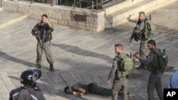 پلیس اسرائیل در اطراف مرد فلسطینی که در کنار دروازه دمشق در حول شهر قدیم اورشلیم قصد حمله با کارد به یک پلیس اسرائیلی داشت. 14 اکتبر