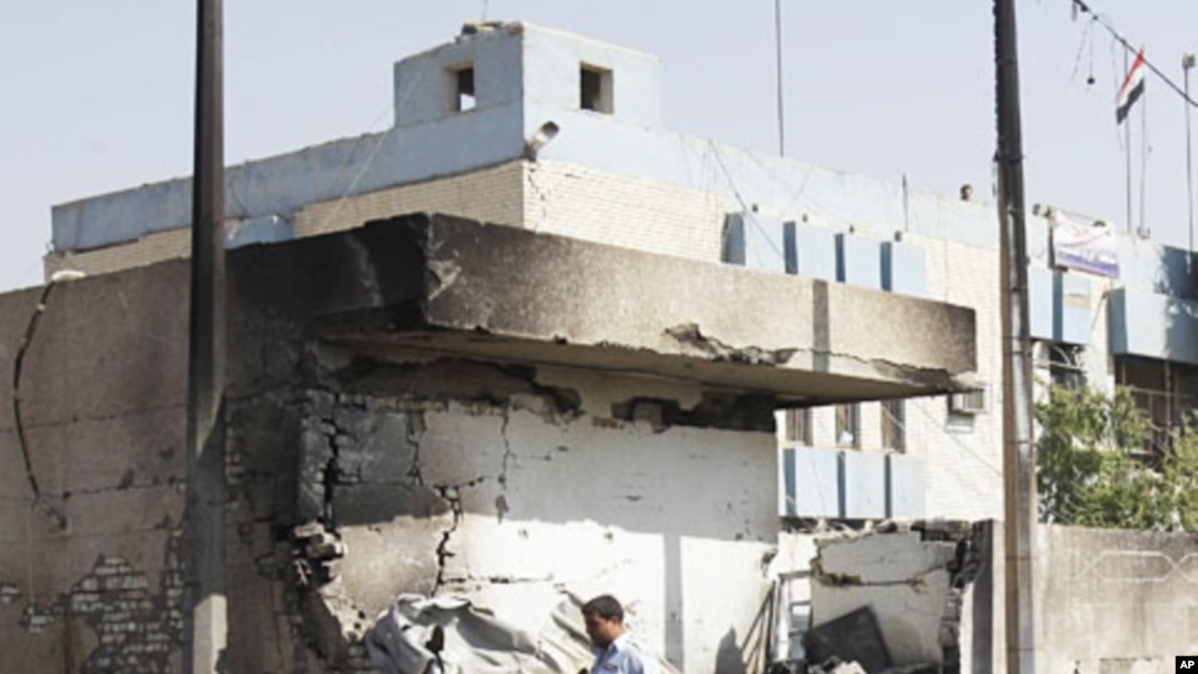 An Iraqi policeman walks past a crater caused by a car bomb attack in front of a police station in Baghdad, Iraq, October 12, 2011.