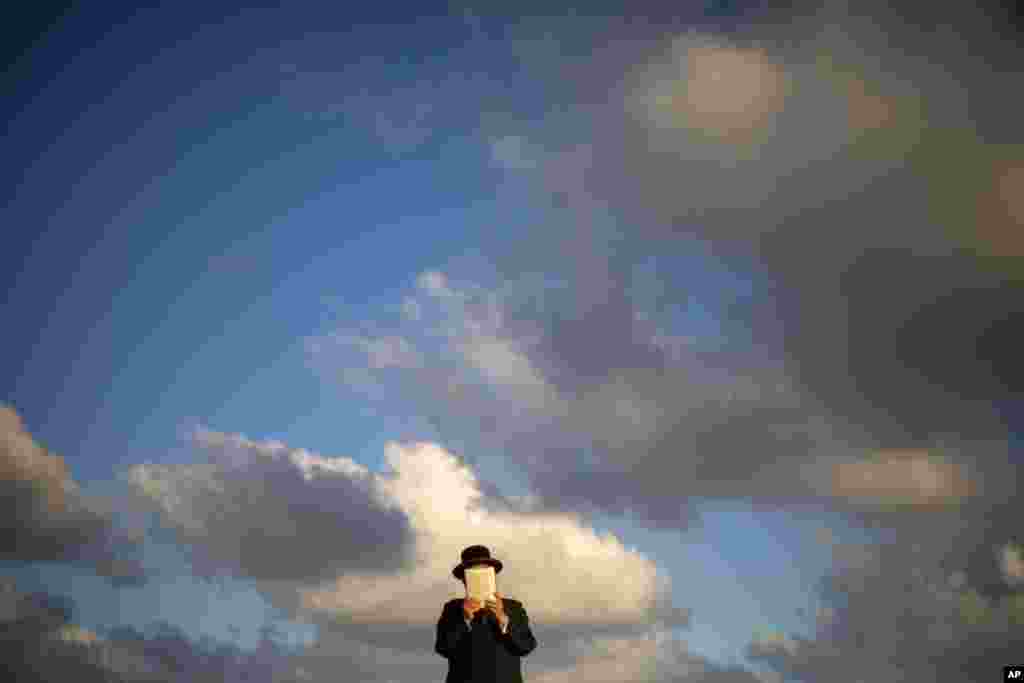 An Ultra-Orthodox Jewish man of the Kiryat Sanz Hassidic sect prays on a hill overlooking the Mediterranean Sea in a Tashlich ceremony, in Netanya, Israel.