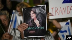 FILE - Women attend a protest against the death of Mahsa Amini, a woman who died while in police custody in Iran, during a rally in Tel Aviv, Oct. 29, 2022. Amini, 22, was held by morality police for allegedly wearing the mandatory Islamic headscarf too loosely.