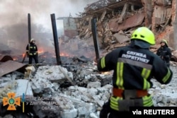 Socorristas se mueven entre los edificios dañados por ataques aéreos rusos en Dnipro, Ucrania, el 11 de marzo de 2022. Foto del Servicio Estatal de Emergencias Ucraniano divulga por Reuters.