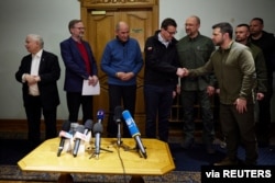 Ukrainian President Volodymyr Zelenskiy shakes hands with Polish Prime Minister Mateusz Morawiecki during a joint news briefing with Ukrainian Prime Minister Denys Shmygal, Czech Prime Minister Petr Fiala, Slovenian Prime Minister Janez Jansa and Polish Deputy Prime Minister Jaroslaw Kaczynski in Kyiv, Ukraine March 15, 2022. (Ukrainian Presidential Press Service/Handout via REUTERS )
