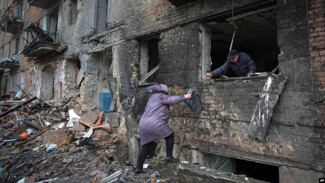 FILE - People gather their belongings from a damaged building after Russian shelling in the town of Vyshhorod, Ukraine, Nov. 24, 2022. The U.N. reports that more than 10 million Ukrainians are facing winter without water, heat or electricity.