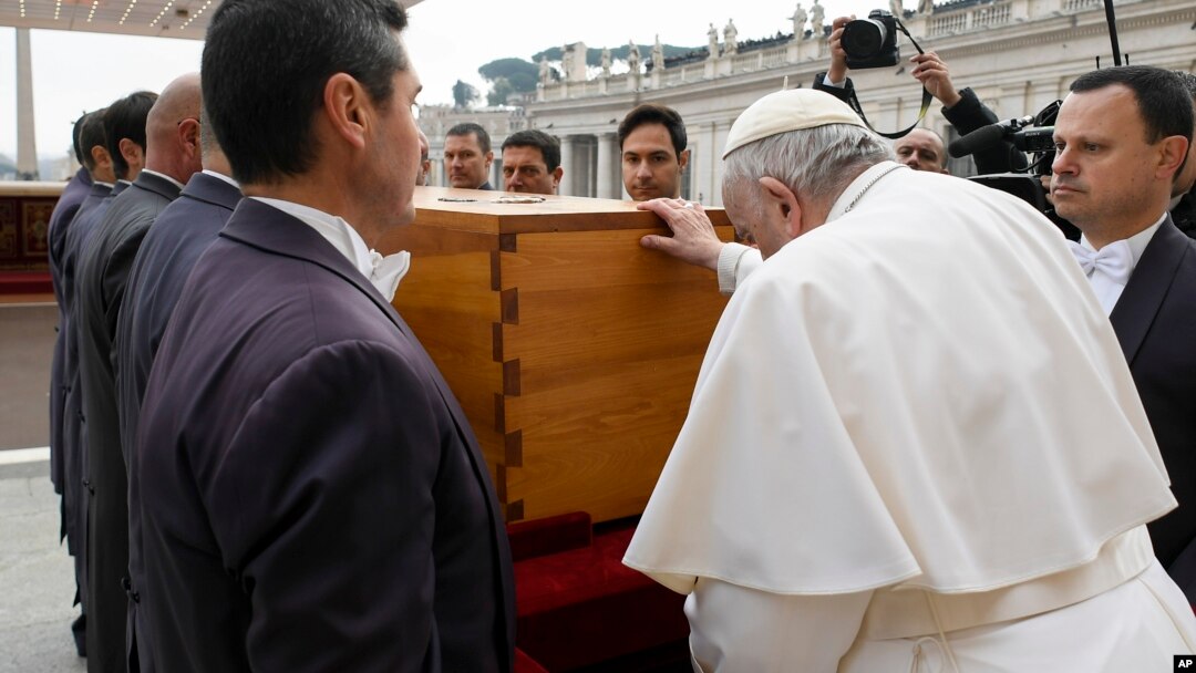 In this image released by the Vatican Media news service, Pope Francis touches the coffin of late Pope Emeritus Benedict XVI after his funeral mass in St. Peter's Square at the Vatican, Jan. 5, 2023.